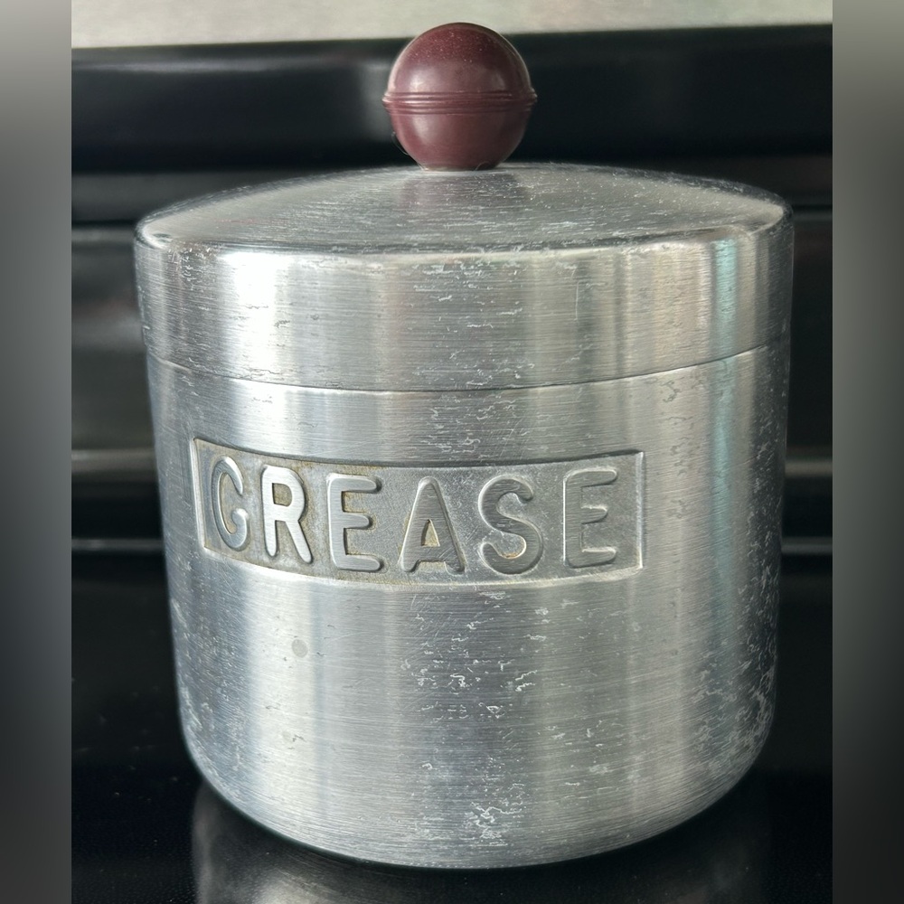 Vintage aluminum grease canister with red bakelite knob